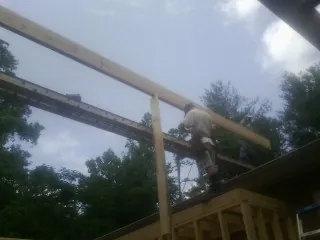 Carpenter setting a ridge beam over a new addition frame — Ice Dam Removal by Roofing Brothers in Melbourne